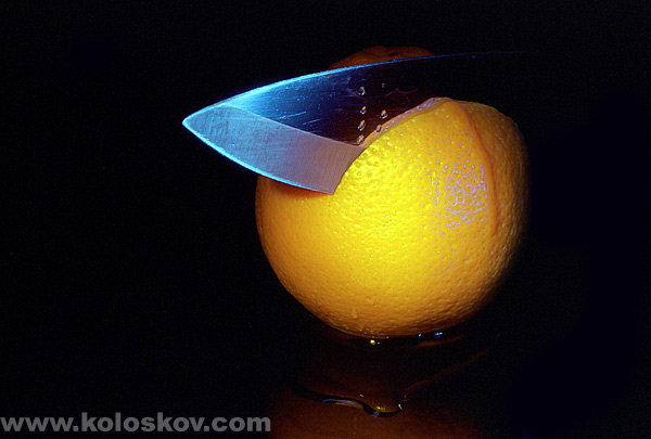  knife cut into lemon on bkack background